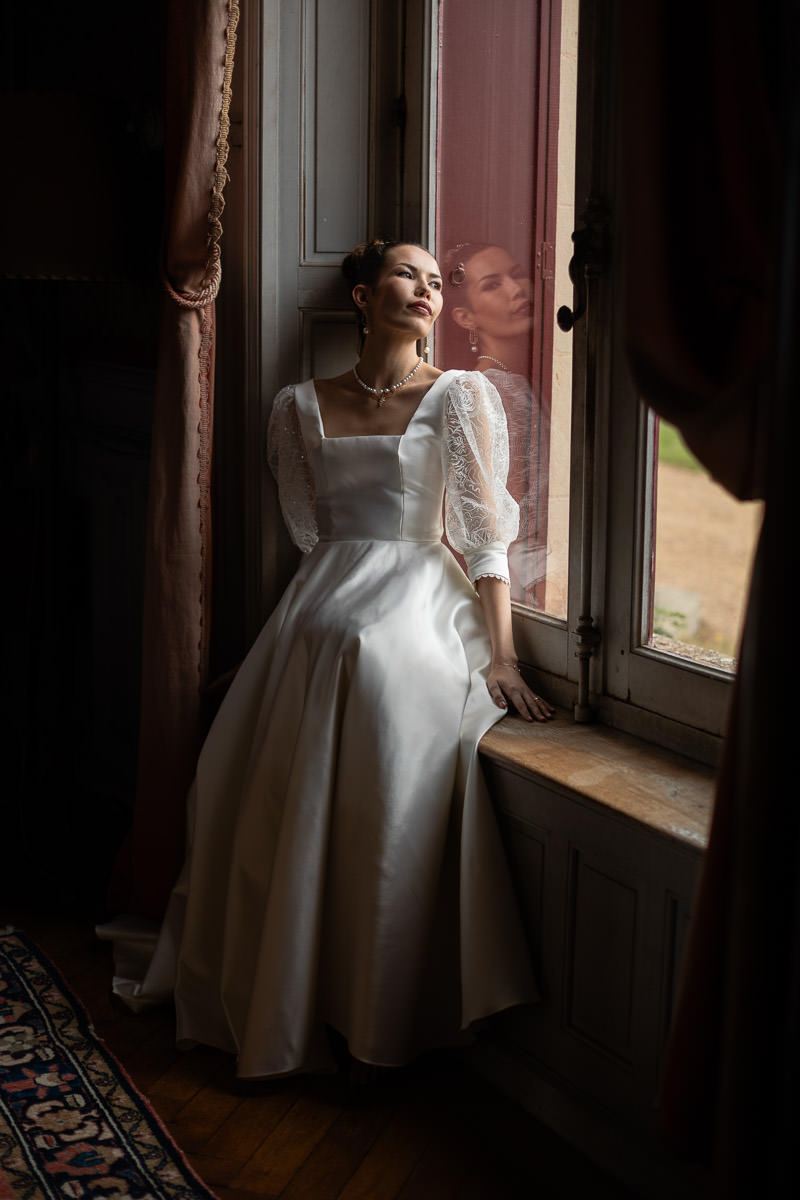 mariée assise à la fenêtre du château Bridgerton